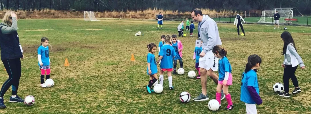 Foundations program running around dribbling with coaches