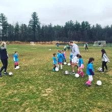 Foundations program running around dribbling with coaches